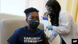 Julian Boyce, 14, menerima dosis pertama dari vaksin COVID-19 Pfizer dalam program vaksinasi yang dilakukan di sebuah Rumah Sakit di Harlem, New York, pada 13 Mei 2021. (Foto: AP/Richard Drew)
