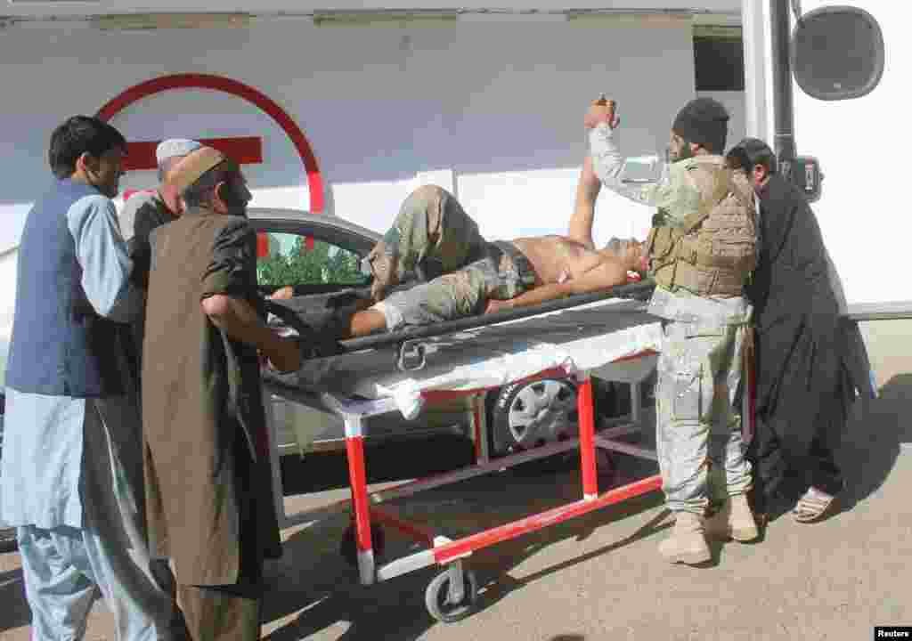 아프가니스탄 헬만드주의 압둘 자바르 카흐라만 의원 사무실에서 폭탄 공격이 있은 후 보안대원들이 부상한 경찰을 실어나르고 있다. 아프가니스탄 총선이 사흘 앞으로 다가온 가운데 선거에 출마한 현지 의원이 폭탄 공격으로 사망했다.&nbsp;