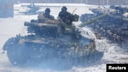 Service members of a mechanized brigade of the Ukrainian Armed Forces drive tanks during military exercises outside Kharkiv, Ukraine Jan. 31, 2022.