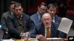 FILE - Russian Ambassador to the United Nations Vassily Nebenzia holds up a copy of a report as he speaks during a Security Council meeting at United Nations headquarters in New York, April 5, 2018.