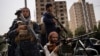 Taliban fighters escort women march in support of the Taliban government outside Kabul University, Afghanistan, Sept. 11, 2021. 