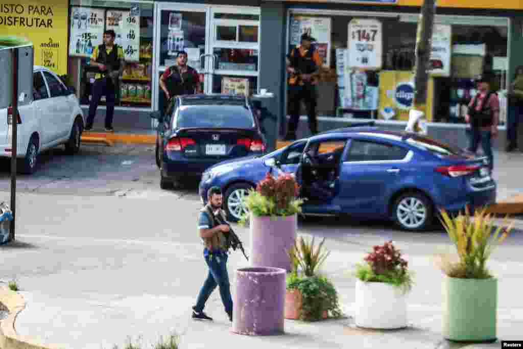 Hombres armados del cártel recorren las calles durante enfrentamientos con las fuerzas federales tras la detención de Ovidio Guzmán.