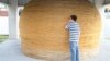A tourist looks at the World's Largest Ball of Twine. (Credit: RoadsideAmerica.com) 