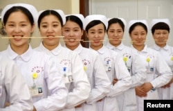 FILE - Nurses practice smiling with chopsticks in their mouths at a hospital in Handan, Hebei province, China, May 8, 2017.