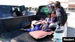 FILE - Civilians, who were wounded by what activists said was violence caused by Islamic State fighters in Kobani, wait with their relatives to cross into Turkey at the Syrian-Turkish border crossing of Tel Abyad, Syria June 25, 2015. 