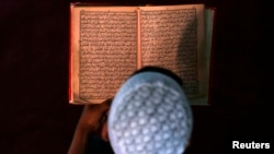 FILE - An Afghan boy reads the Quran in a madrassa or religious school in Kabul.