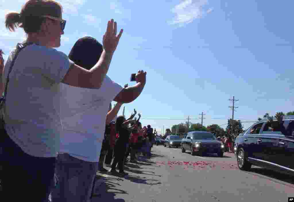 Crowds line the route of the procession led by the hearse carrying the body of Muhammad Ali in Louisville, Ky., June 10, 2016.