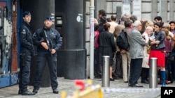 Policemen guard the Jewish museum as people queue for the re-opening ceremony of the museum in Brussels, Belgium, Sept. 14, 2014. 