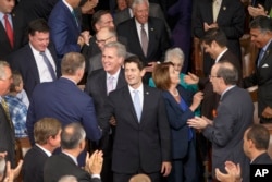 Newly-elected House Speaker Paul Ryan of Wis., escorted by House Minority Leader Nancy Pelosi of Calif., and House Majority Leader Kevin McCarthy of Calif., walks into the House Chamber on Capitol Hill in Washington, Oct. 29, 2015.