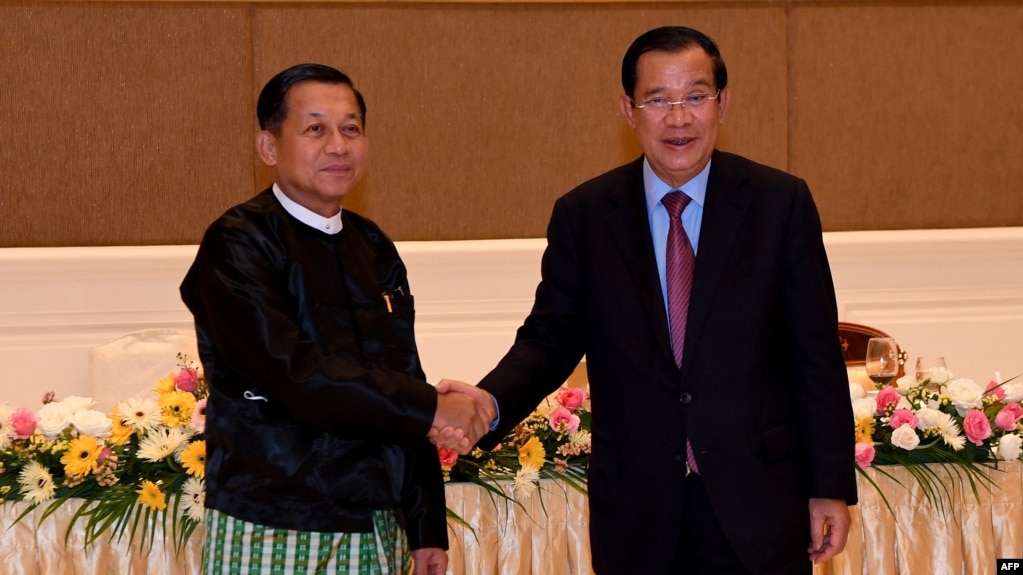 Hun Sen bắt tay tướng Min Aung Hlaing (trái) tại Naypyidaw. (Photo by An Khoun SamAun / National Television of Cambodia (TVK) / AFP)