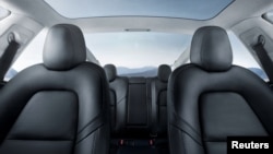 FILE - The interior of the Tesla Model 3 sedan is seen in this undated handout image as the car company handed over its first 30 Model 3 vehicles to employee buyers at the company’s Fremont facility in California, July 28, 2017.