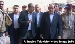Iraqi Prime Minister Nouri al-Maliki, second right, visits a revered Shi'ite shrine in Samarra, Iraq, June 13, 2014.
