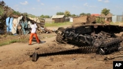 FILE - A man walks past the remains of a tank destroyed during fighting between government and rebel forces on July 10, 2016, in the Jebel area of the capital Juba, South Sudan, July 16, 2016.
