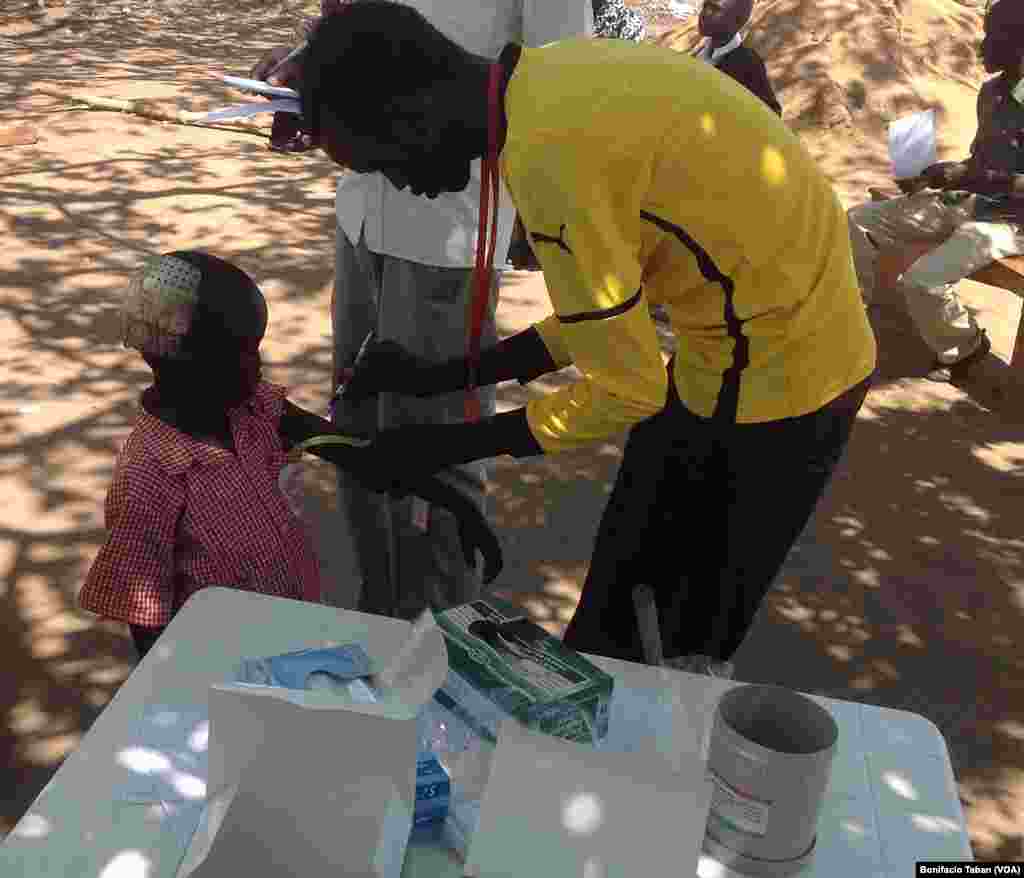 An MSF staffer tests a child's nutrition levels at a refugee resettlement camp in Uganda on March 19, 2014.