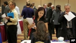 Job seeker Anu Vatal of Chicago, speaks with Patrice Tosi of BluePay, seated, during a career fair in Rolling Meadows, Ill., May 29, 2013.