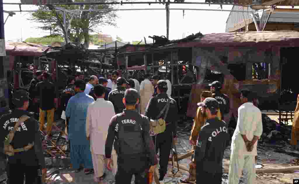 Police commandos stand near the wreckage of a passenger train after a bomb attack in Sibi, Pakistan, April 8, 2014.