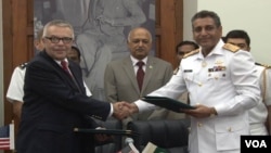 31일 나토 보급로 개방에 대해 합의 후 악수하는 파키스탄 해군 소장 파루크 아흐마드(오른쪽)와 미국 특사. 