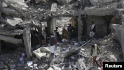 Houthi militants gather on the rubble of the offices of the education ministry's workers union, destroyed by Saudi-led air strikes, in Yemen's northwestern city of Amran, Aug. 19, 2015. 