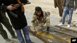 A rebel fighter cleans the ammunition rounds of an anti-aircraft weapon in Ajdabiyah, March 15, 2011