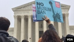 A protester waves a sign at a rally outside the U.S. Supreme Court in Washington, April 25, 2018 (V. Macchi/VOA). Opponents of the Trump administration’s travel ban say the policy discriminates against Muslims, 