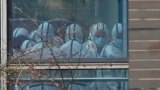 透过窗户可以看到世界卫生组织小组的成员穿着防护装备考察湖北省动物疾病预防控制中心