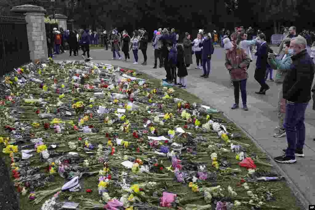 People look at flowers outside Windsor Castle in Windsor, England, to pay tribute to Britain&#39;s Prince Philip, the irascible and tough-minded husband of Queen Elizabeth II.&nbsp;