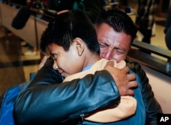 FILE - David Xol-Cholom, of Guatemala, hugs his son Byron Xol-Cholom at Los Angeles International Airport as they reunite after being separated during the Trump administration's wide-scale separation of immigrant families, in Los Angeles, Jan. 22, 2020.