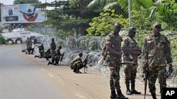 Armed members of the New Forces adopt combat positions near the hotel that houses the rival government declared by Alassane Ouattara in Abidjan, Ivory Coast, 13 Dec 2010