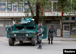 Afghan policemen keep watch a during gunmen attack in Kabul, Afghanistan, May 8, 2019.