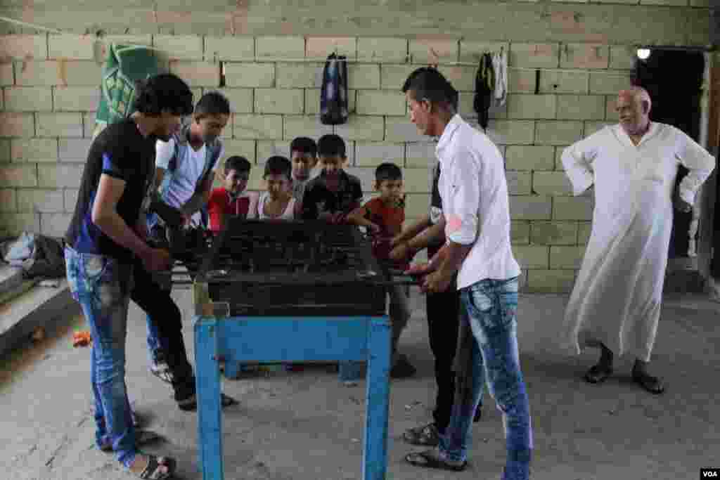 Youngsters play table football at the Ouzai complex. Aid agencies have helped make the half-built university liveable but will not pay for next year's rent. (Photo - J. Owens/VOA)