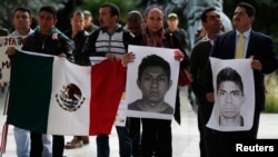 Demonstrators hold Mexican flags and portraits during a protest in support of 43 missing students of the Ayotzinapa teacher training college Raul Isidro Burgos, outside the Mexican Embassy in Bogota, Nov. 7, 2014. 