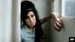 FILE - In this 2007 file photo, British singer Amy Winehouse poses for photographs after being interviewed by The Associated Press at a studio in north London.
