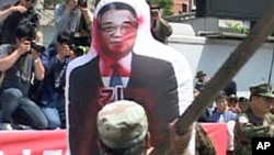 South Korean protesters in Seoul club an inflatable effigy of North Korea's Kim Il Sung, 27 May 2010
