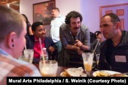 Michael Rakowitz (center, with mustache), brought together American veterans of Iraqi conflicts with Philadelphia-area Iraqi refugees for a group dinner in May 2017.