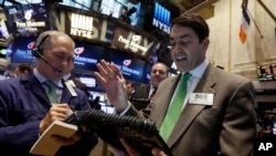 Mark Muller, right, works with fellow traders on the floor of the New York Stock Exchange, Tuesday, May 19, 2015.