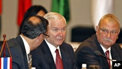 U.S. Defense Secretary Robert Gates, center, listens to his aide while attending the first Association of Southeast Asian Nations (ASEAN) Defense Ministers Meeting Plus at the National Convention Center in Hanoi, 12 Oct. 2010