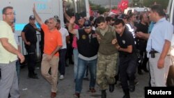 FILE - Soldiers suspected of being involved in the coup attempt are escorted by policemen as they arrive at a courthouse in the resort town of Marmaris, Turkey, July 17, 2016. 
