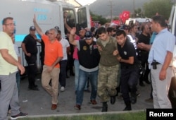 FILE - Soldiers suspected of being involved in the coup attempt are escorted by policemen as they arrive at a courthouse in the resort town of Marmaris, Turkey, July 17, 2016.