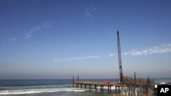 A crane is seen at the border fence as workers renovate the fence between the U.S. and Mexico in Tijuana February 1, 2012.