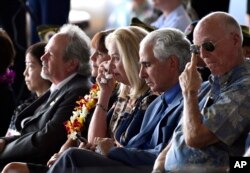 Robert Sanfilkippo, segundo a la derecha, se sienta junto a su esposa, Diana Brown Sanfilippo, quien se ha pasado la vida buscando a su padre, el teniente primero Frank Salazar, quien murió hace 66 años en Corea del Norte, se limpia los ojos durante una ceremonia en Hawái, para recibir los restos de presuntos soldados estadounidenses muertos en la Guerra de Corea.