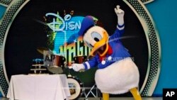 Popular Disney charactor Donald Duck gestures to a cake as he performs on the eve of his birthday during "Disney Magic" event in Bangalore, June 8, 2013. 
