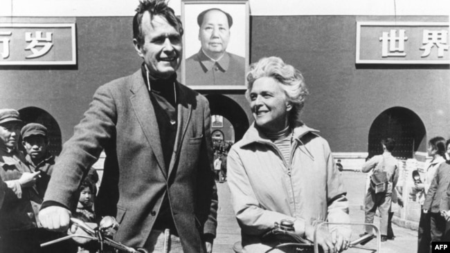 1974年美国驻北京联络处主任乔治·布什（老布什）和夫人骑自行车抵达北京天安门前。 