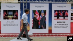 지난 19일 서울에서 열린 한반도 평화 기원 사진전에 도널드 트럼프 미국 대통령과 김정은 북한 국무위원장의 첫 정상회담 사진이 걸려있다.