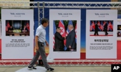 FILE - Photos of the summit between U.S. President Donald Trump and North Korean leader Kim Jong Un are displayed during a photo exhibition to wish for peace on the Korean Peninsula in Seoul, South Korea, Sept. 19, 2018.