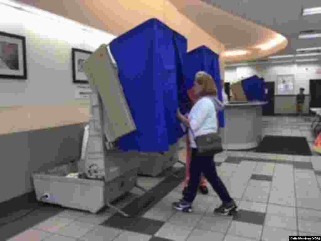 A woman enters a curtained voting machine at a polling station, in Philadelphia, Pa., April 26, 2016. Pennsylvania is one of five Northeast U.S. states voting in presidential primaries Tuesday.