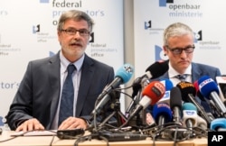 Spokesman for the Belgian Federal Prosecutors Office, Thierry Werts, right, and Belgian Federal Prosecutor Eric Van Der Sypt address the media during a press conference in Brussels on Wednesday, March 16, 2016. Belgian investigators were hunting Wednesday for two suspects who fled an apartment linked to the Nov. 13 attacks in Paris, after a police sniper killed a third man and uncovered weapons, ammunition and an Islamic State flag, officials said Wednesday.
