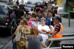 FILE - Venezuelans line up to buy food at a store after a strike called to protest against Venezuelan President Nicolas Maduro's government in Caracas, Venezuela, July 29, 2017.