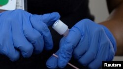 Seorang perawat dari San Diego County mengumpulkan sampel dari seorang pasien di lokasi tes Covid-19 di tengah wabah virus corona, di San Diego, California, 25 Juni 2020. (Foto: Reuters)