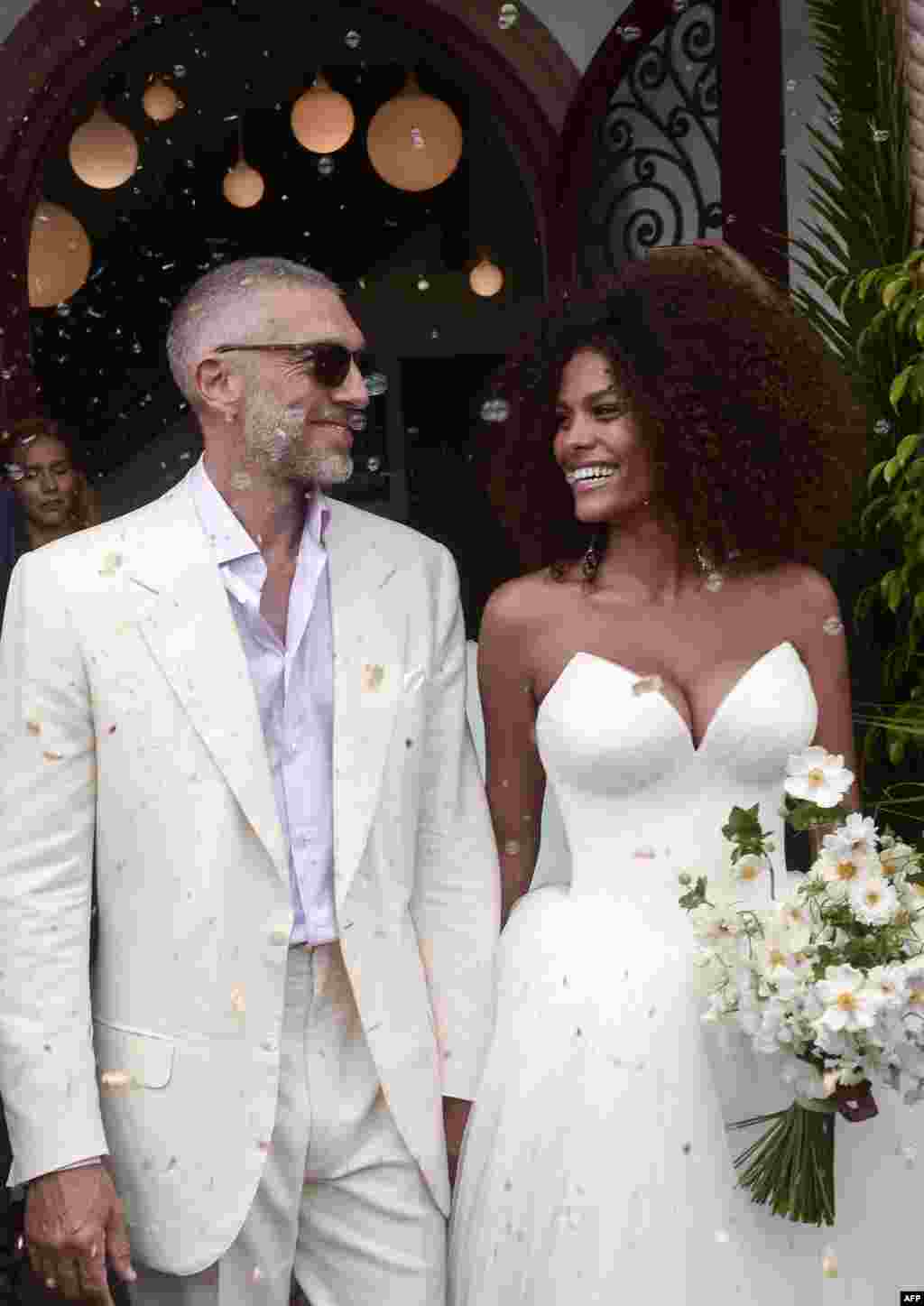 តារាសម្តែងជនជាតិបារាំង Vincent Cassel (ឆ្វេង) និងតារាបង្ហាញម៉ូដជនជាតិបារាំងដូចគ្នា Tina Kunakey កំពុងចាកចេញពីពិធីអាពាហ៍ពិពាហ៍របស់ពួកគេ នៅសាលាក្រុង Bidart នៅភាគនិរតីនៃប្រទេសបារាំង។