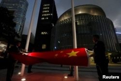 A Chinese national flag is lowered outside the Legislative Council, part of a daily ceremony in Hong Kong, Nov. 7, 2016. The day before, China's parliament passed an interpretation of Hong Kong's Basic Law saying lawmakers must swear allegiance to the city as part of China.